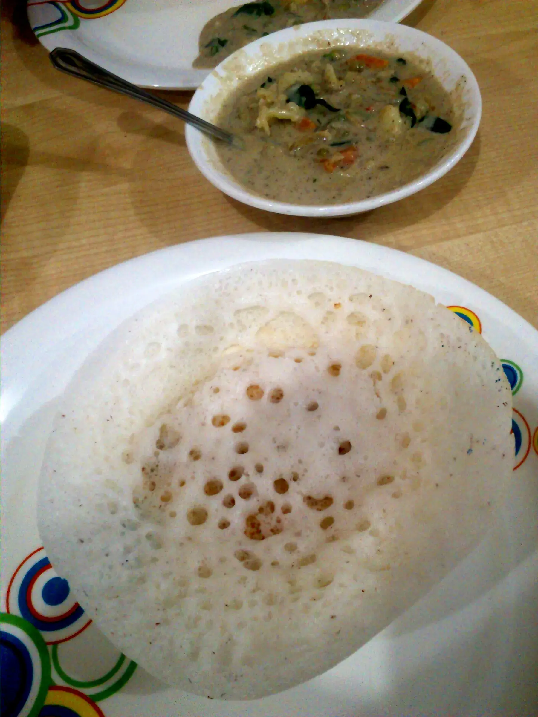 Appam served with a vegetable stew
