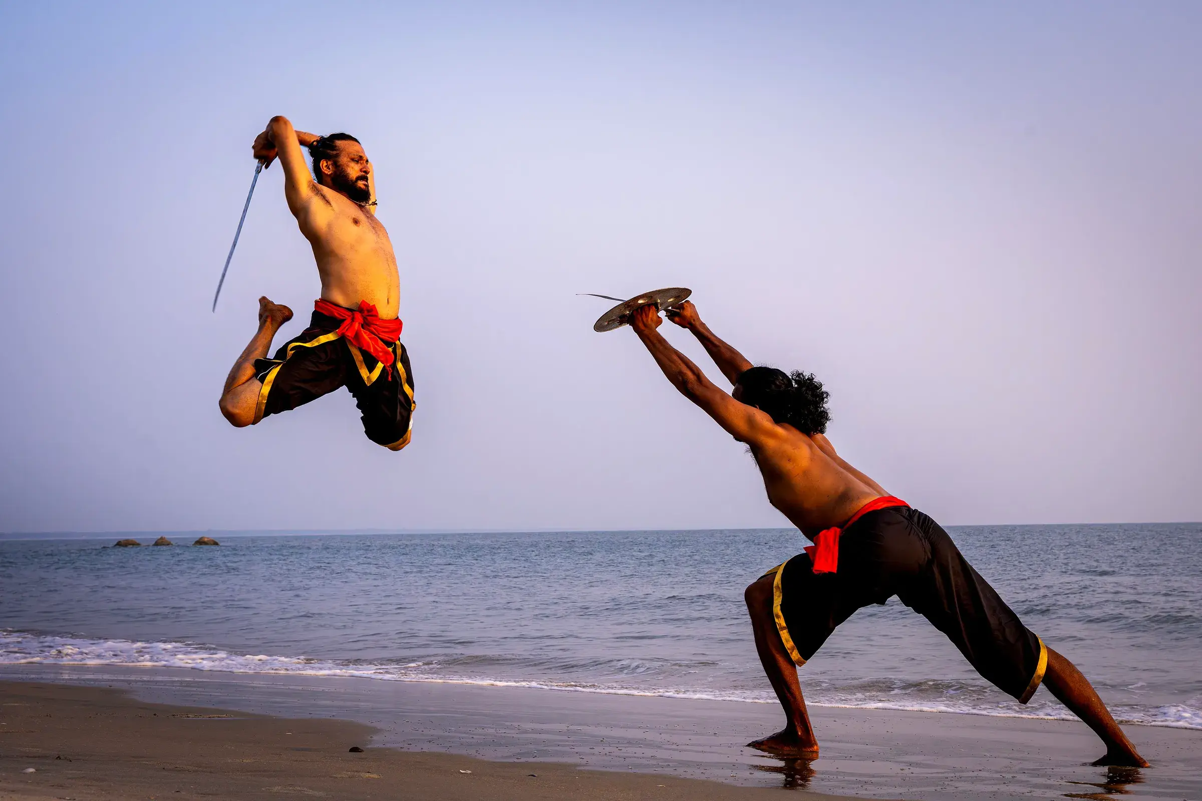 Two Kalaripayattu practitioners sparring with weapons
